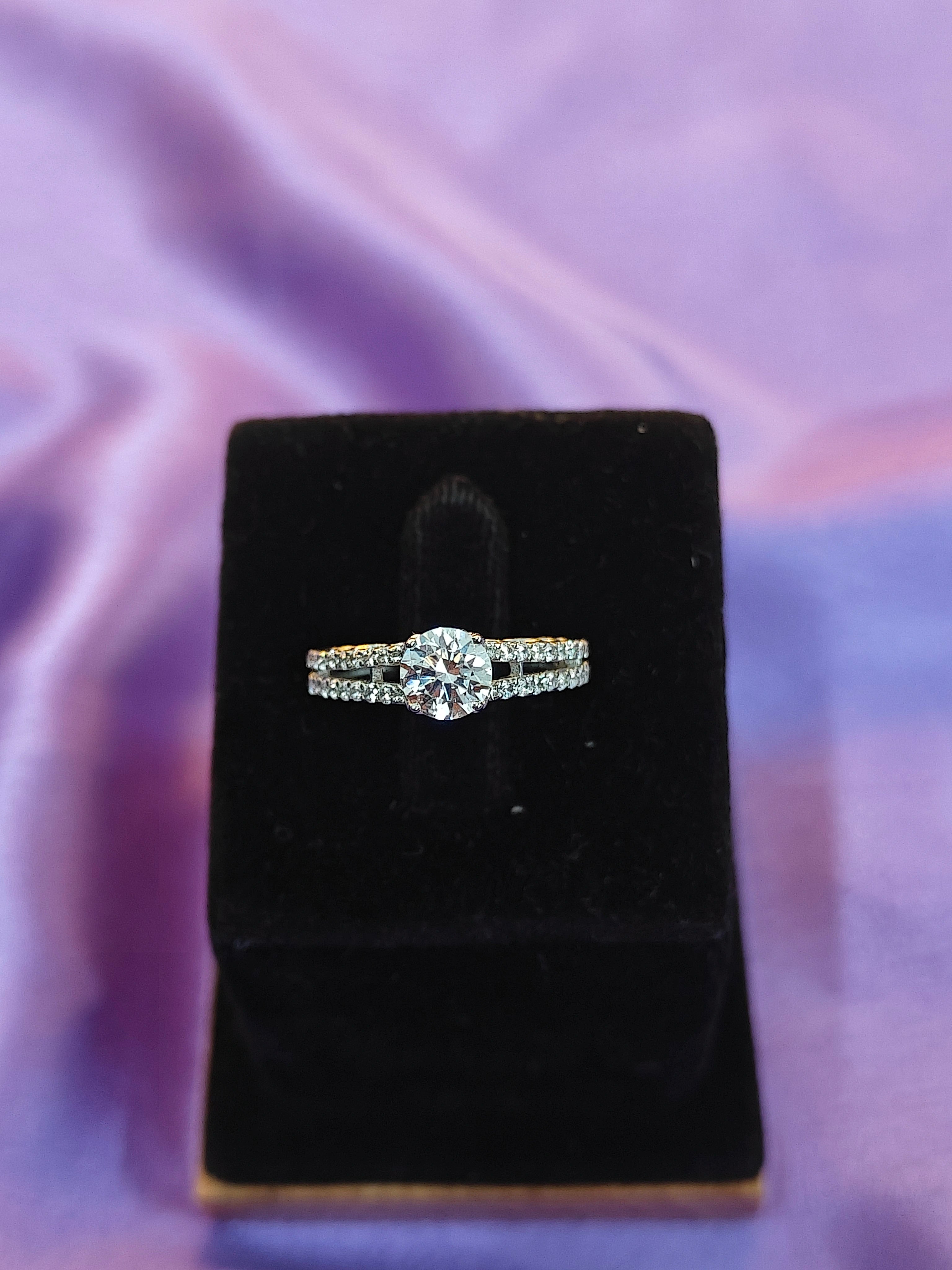 Diamond ring on a black velvet stand with a purple fabric background
